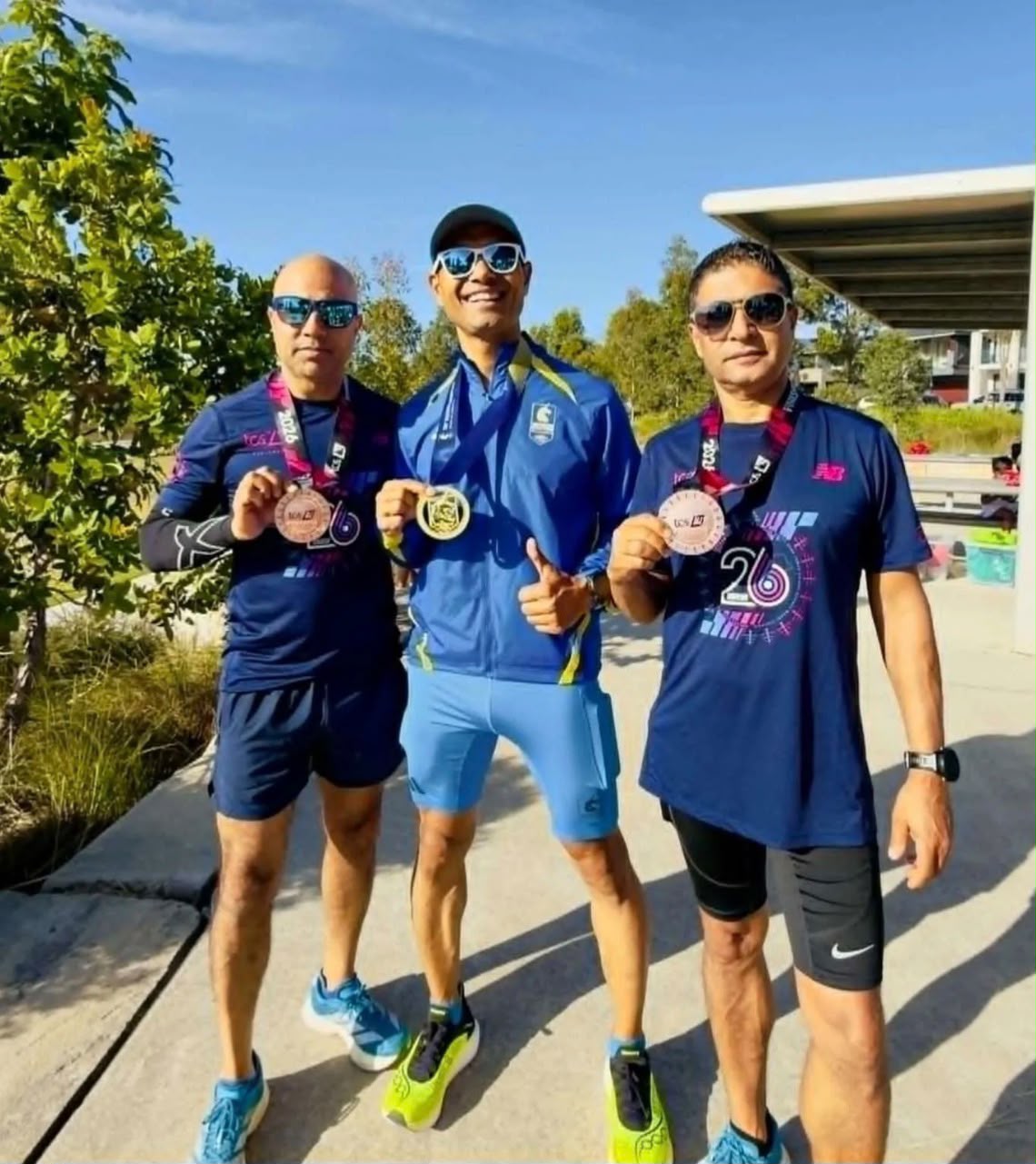 Three NRA runners smiling with finisher medals